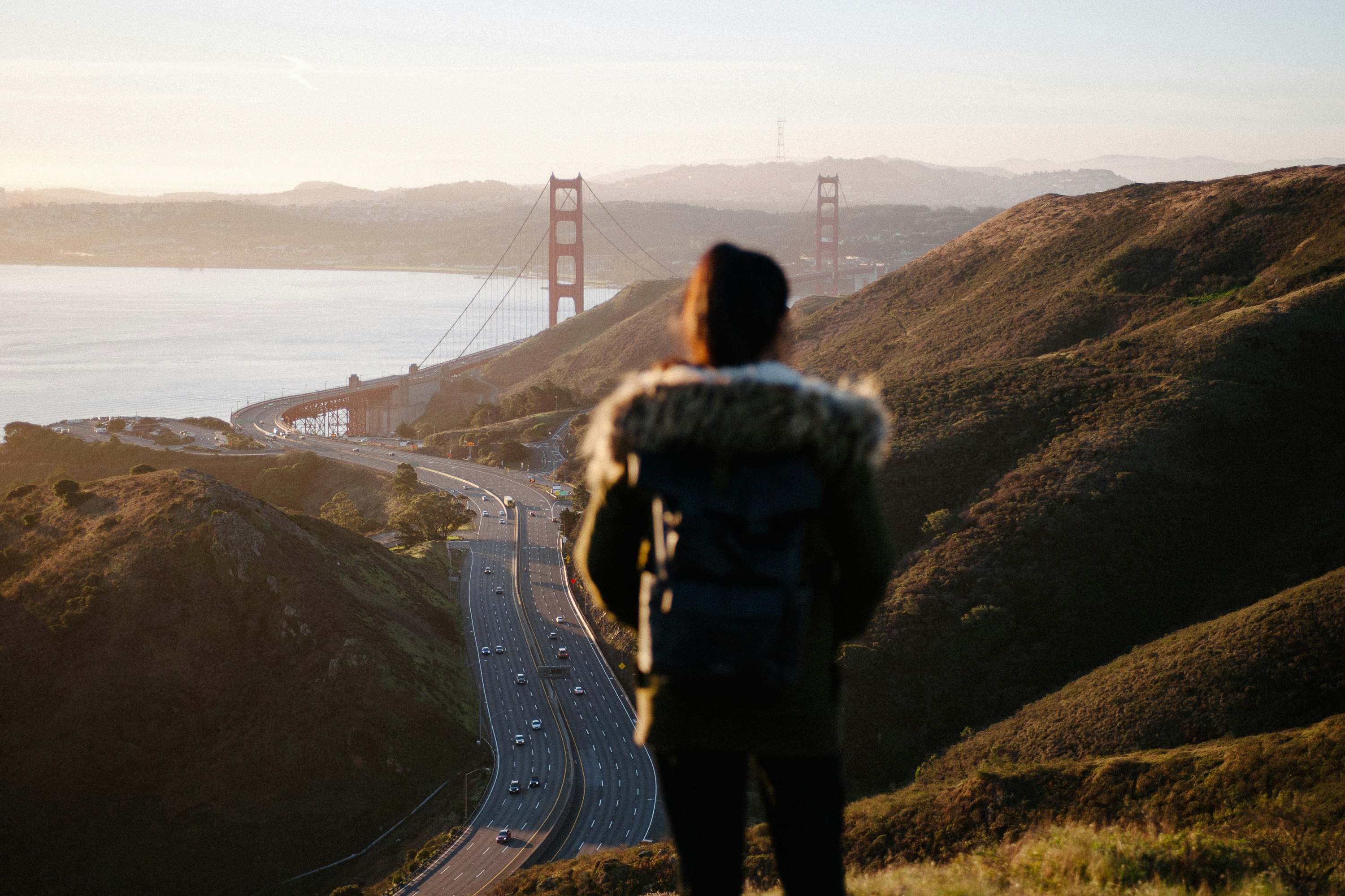 woman in black jacket standing on the edge of the mountain during daytime